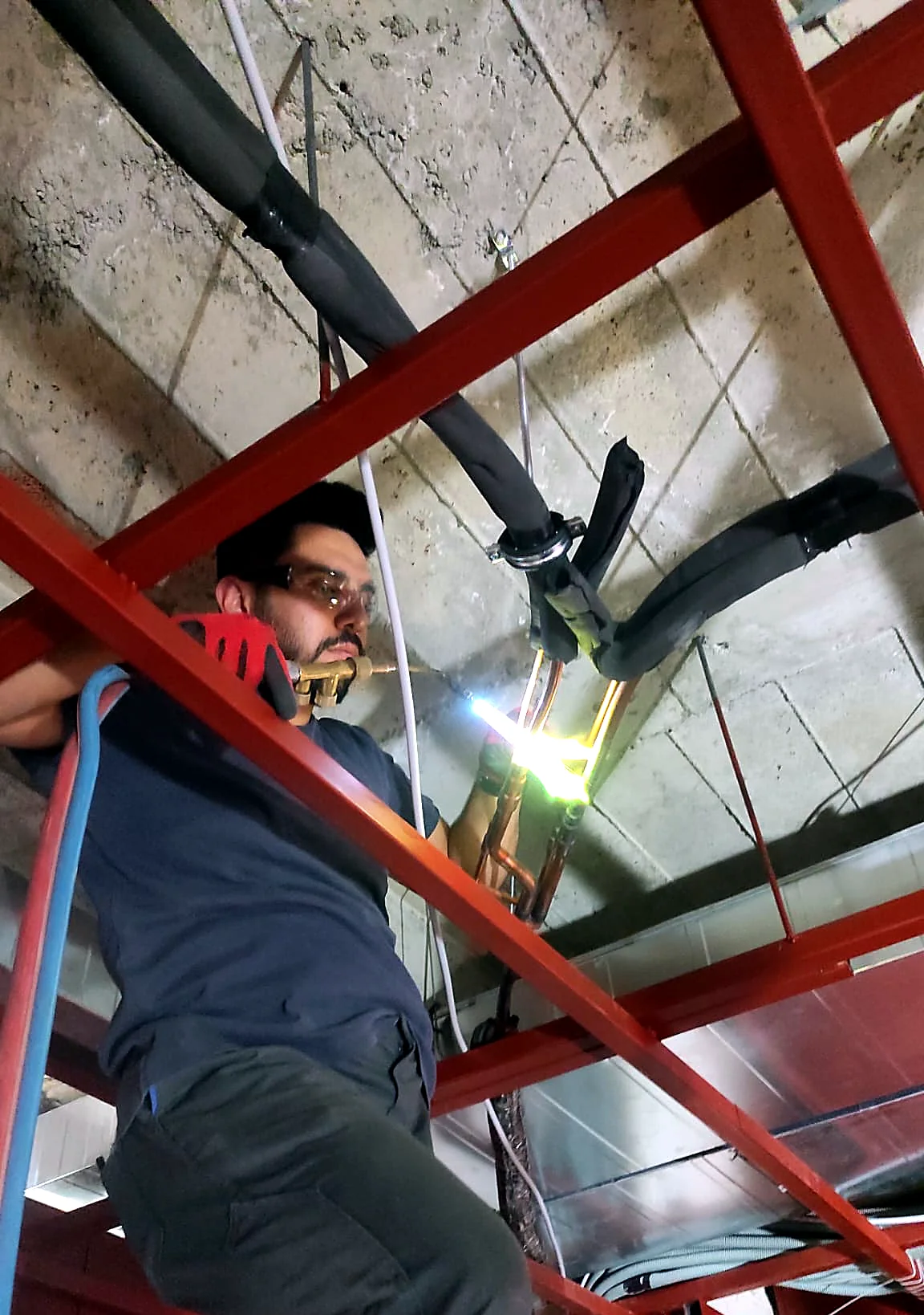 Teknisyen tavandaki bakır boru branşmanında kaynak yapıyor