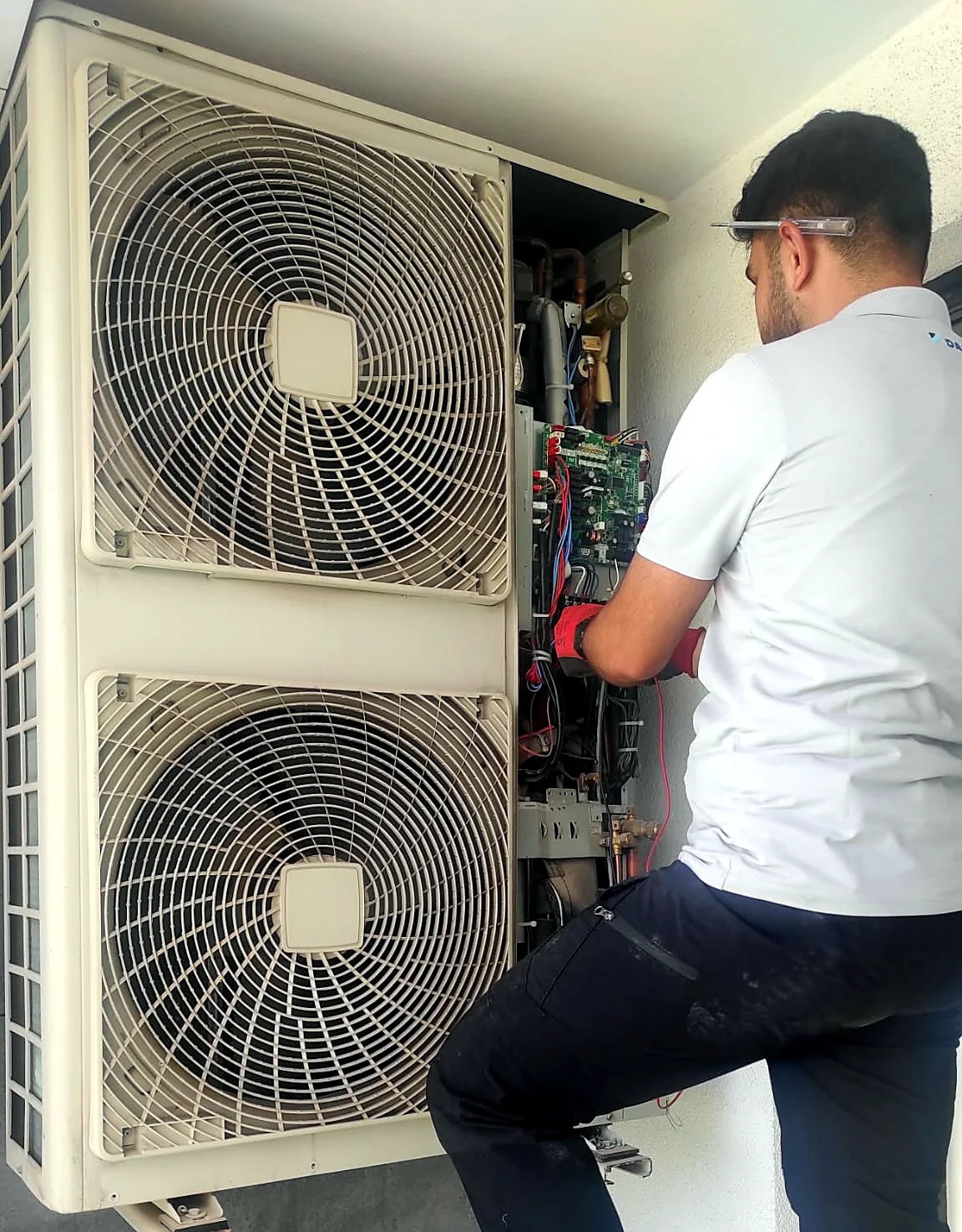 Teknisyen iki fanlı VRV dış ünitenin elektronik kartında ölçüm yapıyor